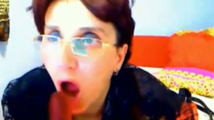 Four eyed older bitch is sucking her big dildo like a woman possessed