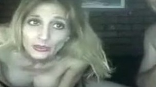 Slutty blonde whore showing her tits while smoking on the web camera